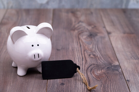 The photo shows a piggy bank with a blank slate, which provides space for text