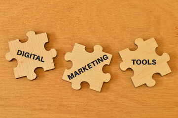 Wooden jigsaw puzzle with text DIGITAL MARKETING TOOLS.