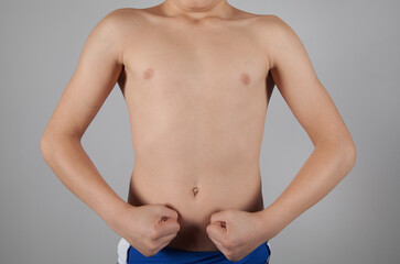 Strong boy with a fist. Gray background.