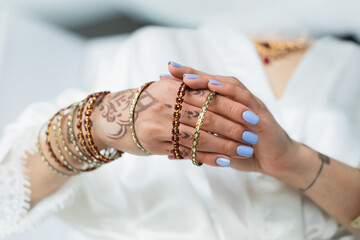 cropped view of indian bride with mehndi wearing bracelets