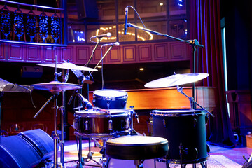 shot showing drum kit with multiple drums cymbals snares bass and more placed on a stage ready for...