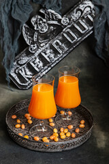 Halloween background with orange drink in glass, selective focus