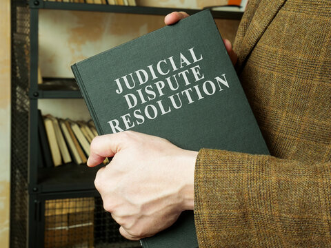Man shows judicial dispute resolution JDR book.
