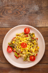 Risotto with mushrooms in a beige plate on a wooden background.