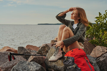 Female brushing hair off her face on riverside