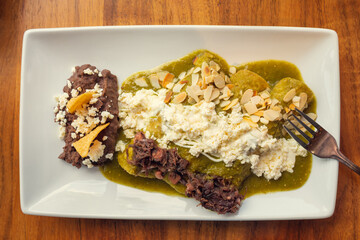 Gourmet green enchiladas with beans. Traditional Mexican food with beans. Traditional Mexican gourmet food concept, traditional green enchiladas