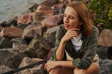 Female sitting deep in thought near the river