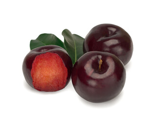 Three plums with leaves on white background