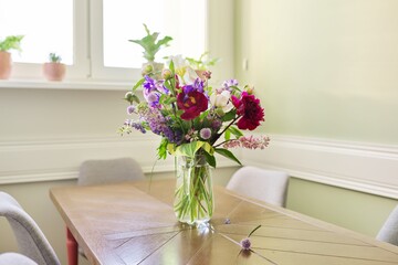 Fototapeta na wymiar Bouquet of bright flowers on the table in jug