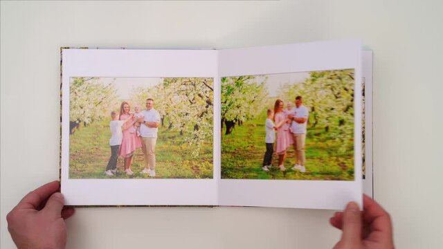 white background leaf through photobook from family photo shoot in spring garden