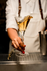 Great transparent glass with splashing alcoholic drink in the hand of woman.