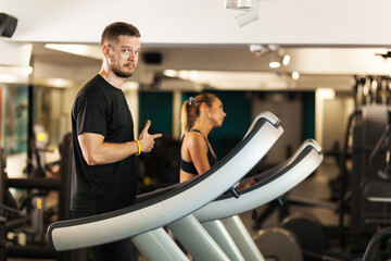 Couple working out on a treadmil in a fitness club.