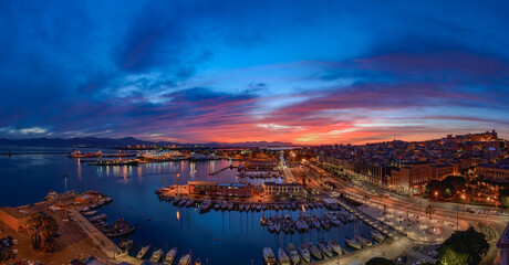 Cagliari, Italy 12-06-2021. Panoramic view of Cagliari at sunset view of the harbor. Cagliari at night seen from above.  Amazing view of Cagliari city with ships and boats moored at the port.