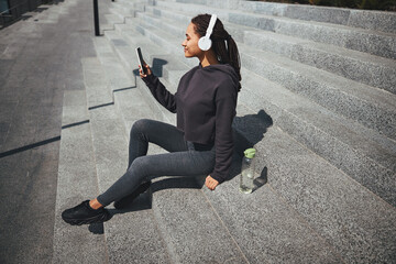 Smiling attractive woman looking at the smartphone in her hand