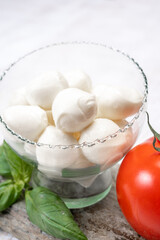 Fresh white soft mini mozzarella balls served with red tomato and fresh green basil