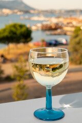 Summer on French Riviera, drinking cold white wine from Cotes de Provence on outdoor terrase with view on harbour of Toulon, Var, France