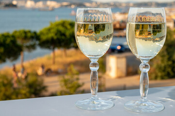 Summer on French Riviera, drinking cold white wine from Cotes de Provence on outdoor terrase with view on harbour of Toulon, Var, France