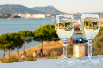 Summer on French Riviera, drinking cold white wine from Cotes de Provence on outdoor terrase with view on harbour of Toulon, Var, France