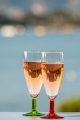 Summer party, drinking of French champagne rose sparkling wine in glasses with view on fishermen harbour of Toulon, France