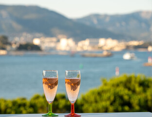 Summer party, drinking of French champagne rose sparkling wine in glasses with view on fishermen harbour of Toulon, France