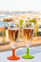 Summer party, drinking of French champagne rose sparkling wine in glasses with view on fishermen harbour of Toulon, France