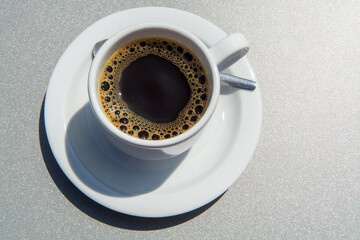 White cup of black coffie on gray background