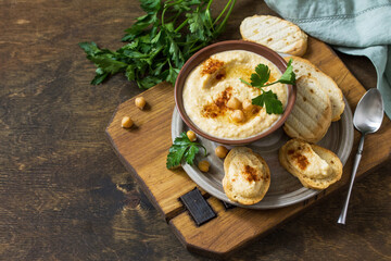 Middle Eastern, Hummus Arabic Cuisine. Vegetarian dips Homemade chickpea hummus with olive oil, paprika on a rustic table. Copy space.
