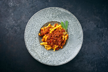 Modern style traditional casarecce al bronzo al rag italian pasta with minced meat tomato ragu sauce served as top view on a Nordic design plate with copy space