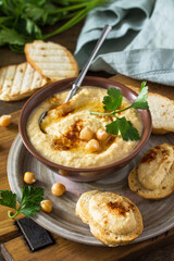 Middle Eastern, Hummus Arabic Cuisine. Vegetarian dips Homemade chickpea hummus with olive oil, paprika on a rustic table.