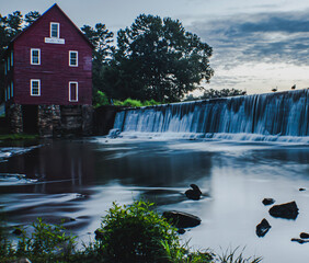 beautiful sunrise waterfall at the historic Starr's Mill in Fayette County Georgia with active wildlife all around