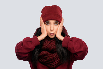 Cheerful and emotional  brunette girl with beautiful makeup, with clean skin, long hair in a burgundy  winter sweater and in a hat . New Year concept