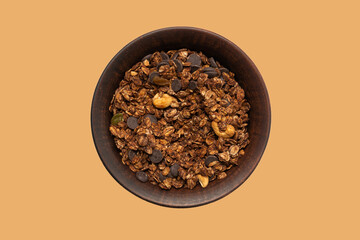 Chocolate granola cereal with nuts in a bowl background.