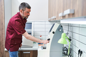 Optician using modern optical equipment in clinic