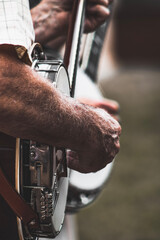 close up of mature adult men playing banjos in the park