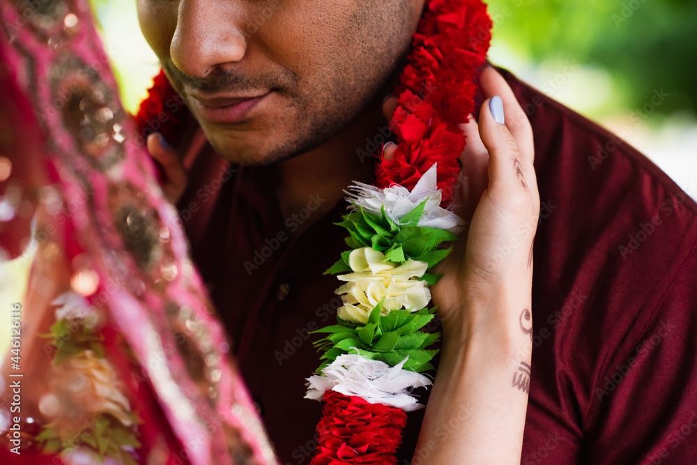 Wall mural cropped view of indian bride wearing floral garland on bridegroom