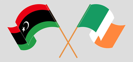 Crossed and waving flags of Libya and Ireland