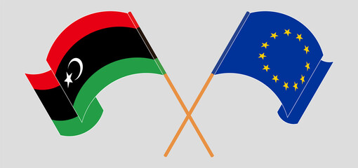 Crossed and waving flags of Libya and the European Union