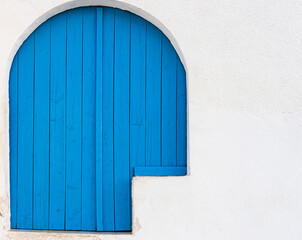 Blue door in a house with a white facade and Mediterranean style.