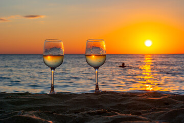 Two glasses of wine on a beach at sunset, Sicily island, Italy