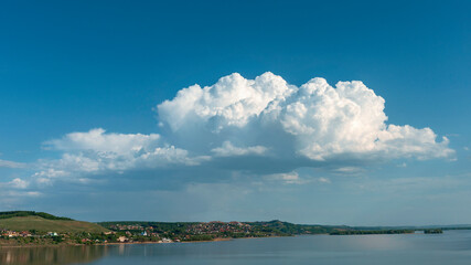 Beautiful blue sky with white clouds over a large lake with steep banks