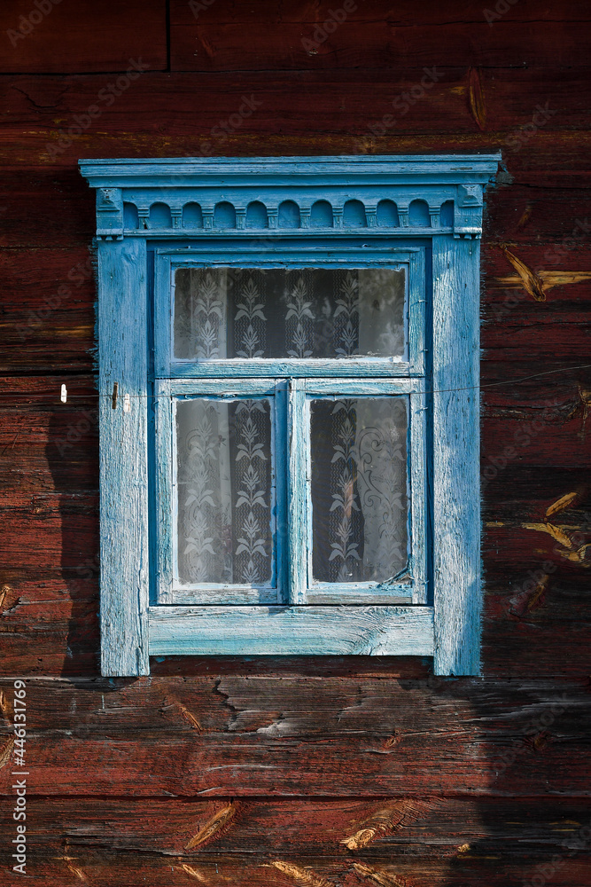 Wall mural Blue painted window of an old rustic wooden hut, grunge background.