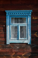 Blue painted window of an old rustic wooden hut, grunge background.