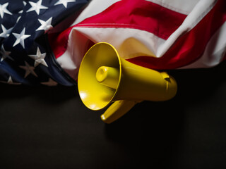 Fake news, elections, debates. American flag and yellow megaphone. Color image. Dark gray simple...