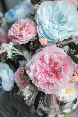 Arrangement of flowers in a round vase. Pink and blue color floral arrangement on white background. Interior decor.