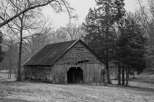 abandoned barn with snow during winter in monochrome with winter weather in background