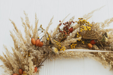 Stylish autumn rustic wreath close up. Creative boho wreath with dried pampas grass, tansy...