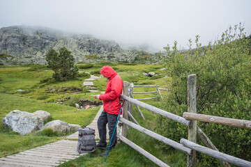 man stopping to check his cell phone on a trekking route