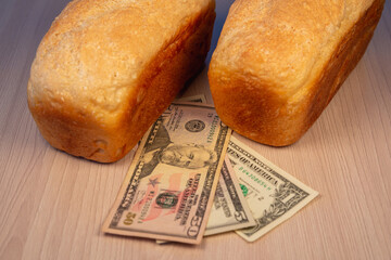 Money (dollars) and bread. Rise in price of bread.