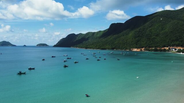 Aerial view. Establishing shot. Traditional fishing boats are floating in the harbor on the remote tropical island. Hidden paradise somewhere southeast Asia. Coracle.