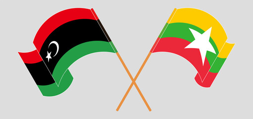 Crossed and waving flags of Libya and Myanmar